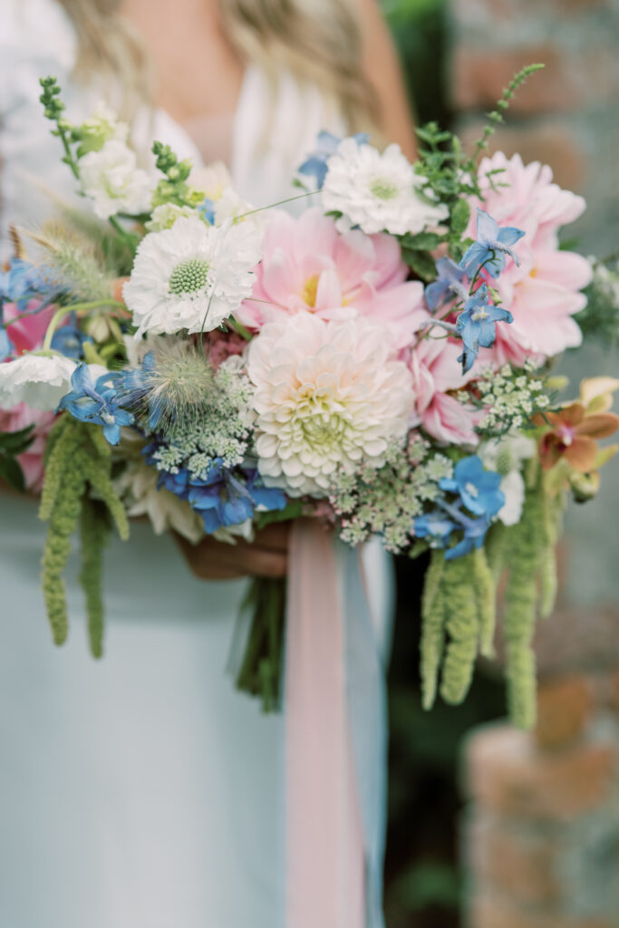 Loose unstructured bridal bouquet with locally grown dahlias, scabious and blue delphinium