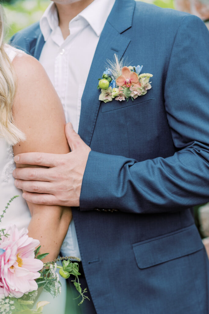 Groom wearing a colourful seasonal flower buttonhole