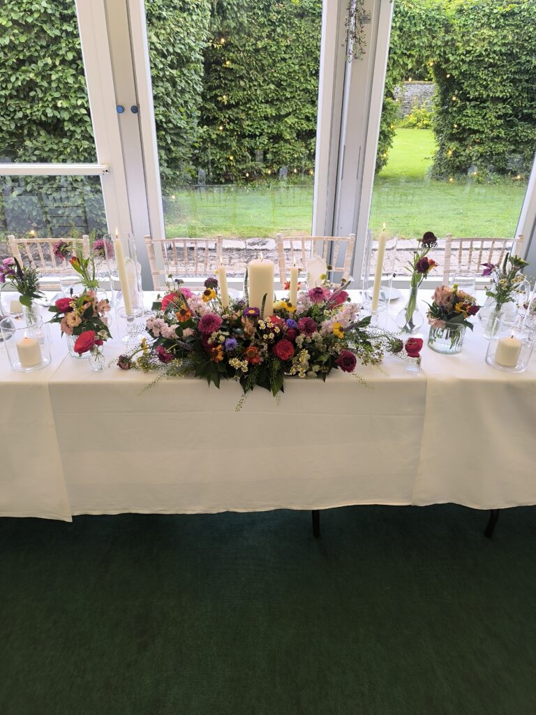Wildflower-style top table flowers at Martinstown House wedding