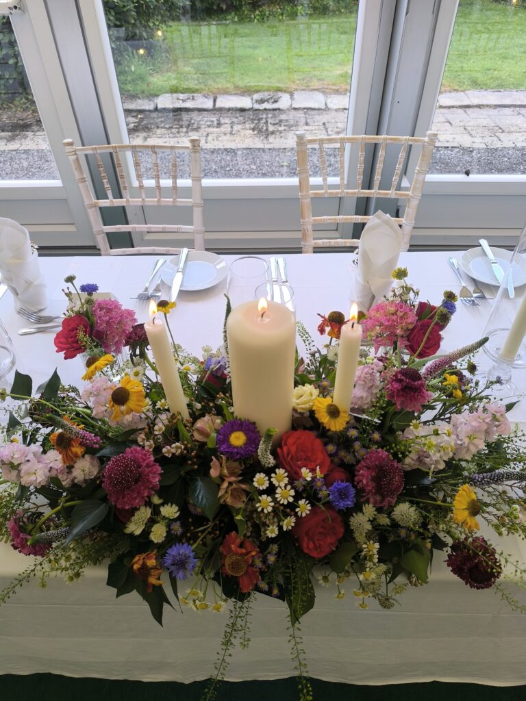 Colourful top table flowers and candles at Martinstown House, Kildare